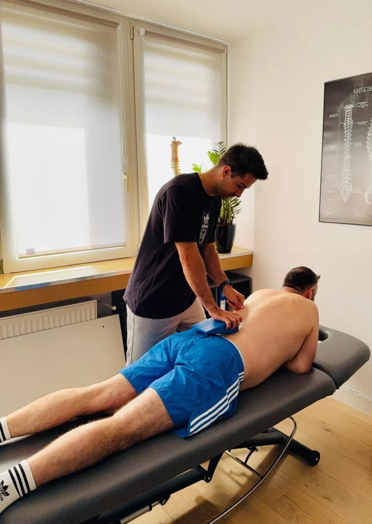 Fizjoterapeuta wykonujący mobilizacje stawów na pacjencie leżącym na stole