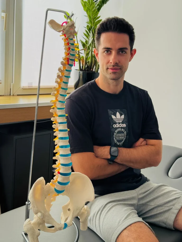 Fizjoterapeuta siedzący obok modelu kręgosłupa